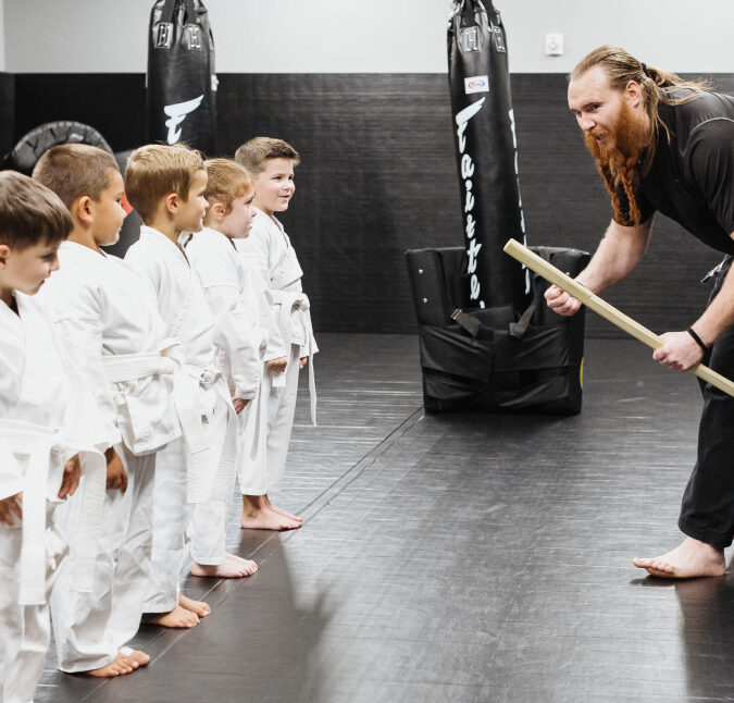 trainer teaching preschoolers in a martial arts class
